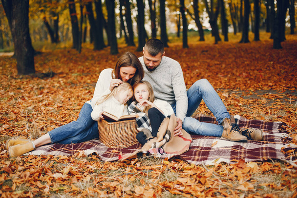 Family in a autumn park. Woman in a red sweater. Cute childrens with parents - Foto, Bild