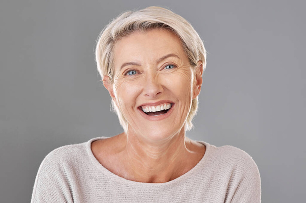 Grooming, skincare and face of happy mature woman laughing against a studio grey background. Senior female feeling fresh, enjoying free time with self care hygiene treatment. Joy after routine pamper. - Zdjęcie, obraz