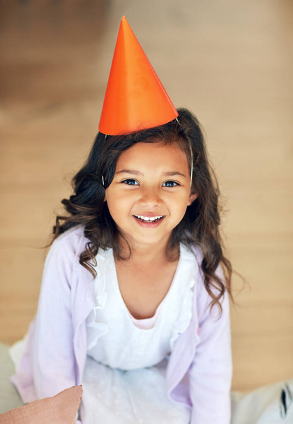 Im ready, wheres the party. Portrait of a cute little girl wearing a party hat at home - Fotografie, Obrázek