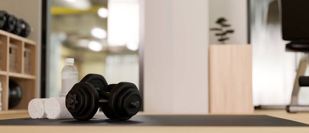 Dumbbells, towels and a bottle of water on a exercise mat over blurred modern fitness gym in the background. close-up image. 3d rendering, 3d illustration - Foto, afbeelding