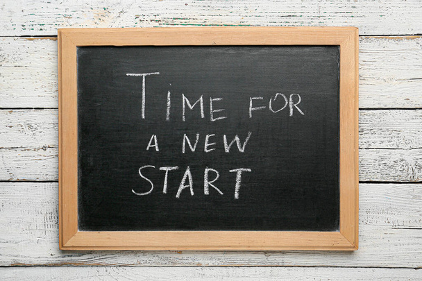 Chalkboard with text TIME FOR A NEW START on white wooden background - Foto, immagini