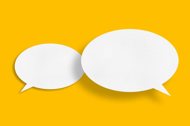 White paper in speech bubble shape set against yellow background.Communication bubbles. - Φωτογραφία, εικόνα