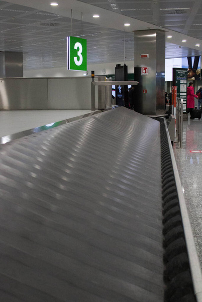 image évocatrice de la courroie transporteuse pour la livraison des bagagesen soute dans un aéroport en Italie - Photo, image