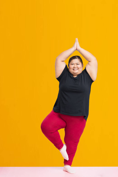 Asian fat woman workout isolated on yellow background, Clipping paths for design work empty free space - Foto, immagini