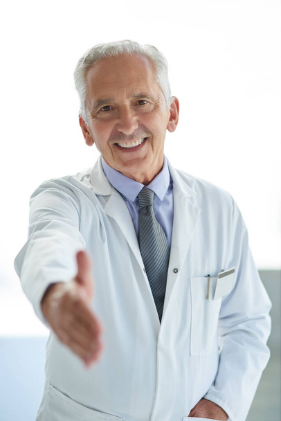 Allow me to take care of your health. Portrait of a mature doctor extending a handshake - Foto, Bild