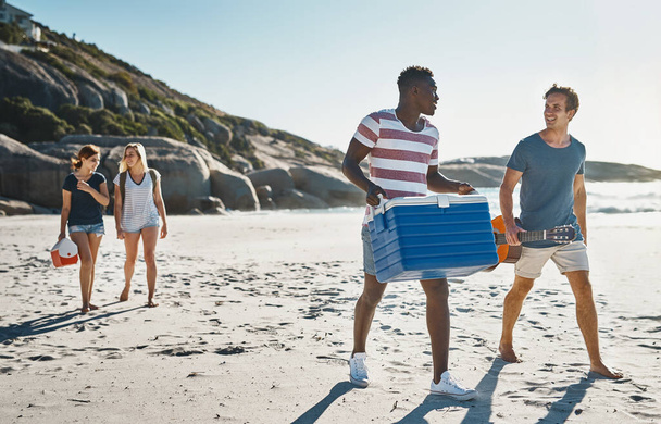 З нетерпінням чекаємо холодного заварювання на пляжі. група молодих друзів, що гуляють на пляжі в сонячний день
 - Фото, зображення