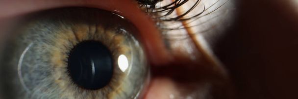 Vrouwelijke oog met zwart geschilderde wimpers close-up. Laservisiecorrectie - Foto, afbeelding