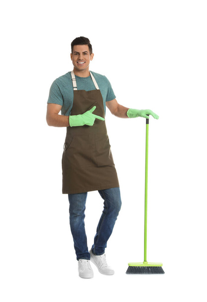 Man with green broom on white background - Foto, afbeelding