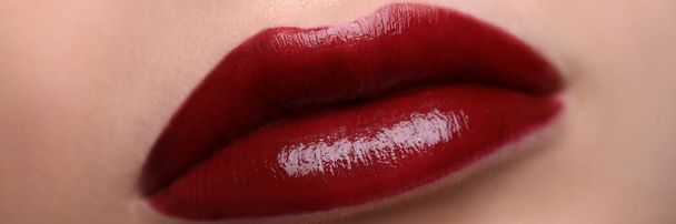 Zbliżenie pięknych ust kobiety z czerwoną szminką. Koncepcja profesjonalnego makijażu - Zdjęcie, obraz