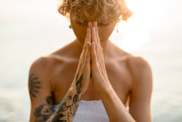 Close-up of beautiful young woman with hands in praying yoga pose outdoor. Healthy life concept. - Fotoğraf, Görsel