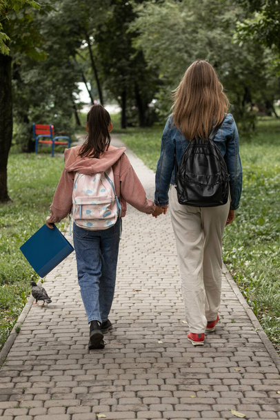 Mother walks her daughter to school. A walk in the park. - Fotó, kép