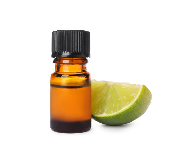 Bottle of citrus essential oil and cut fresh lime isolated on white - Fotoğraf, Görsel