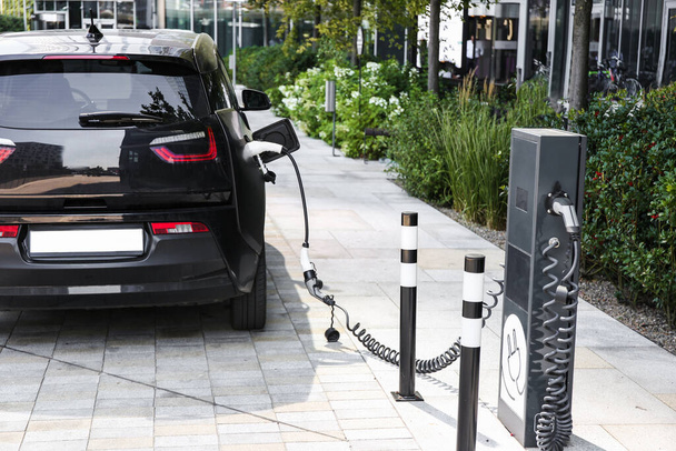 открытые зарядные станции для электромобилей, Электрический автомобиль меняется на улице парковки - Фото, изображение