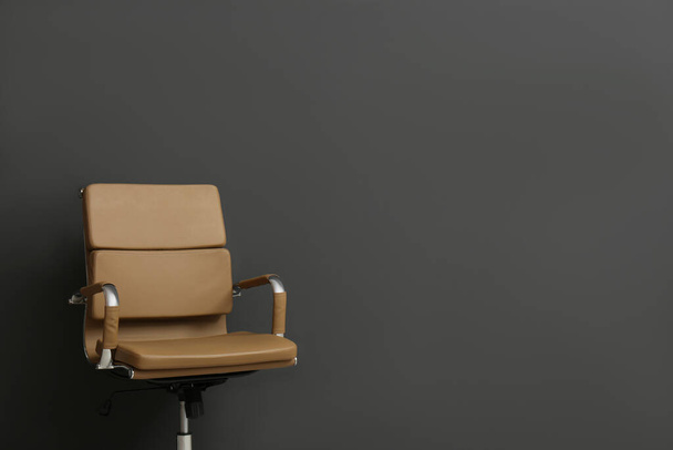 Комфортне офісне крісло на чорному тлі. Простір для тексту
 - Фото, зображення