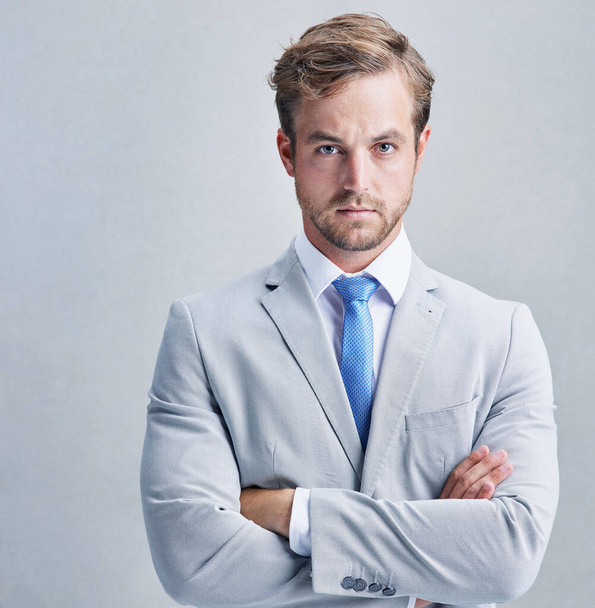 I refuse to be second best. Studio shot of a businessman in a grey suit posing against a grey background - Photo, image