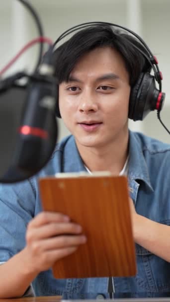 Asian podcaster making audio podcast working at home studio. - Felvétel, videó