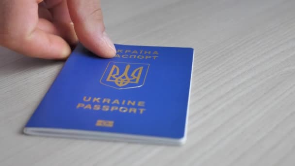 Ukrainian biometric passport for traveling in Europe on the table. Inscription in Ukrainian Passport of Ukraine. Travel or migrant concept - Video, Çekim