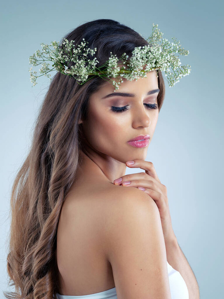 Fresh and feminine for that springtime look. Studio shot of a beautiful young woman wearing a floral head wreath - Zdjęcie, obraz