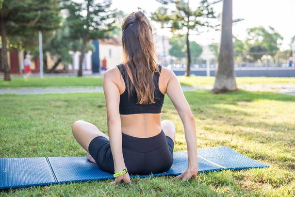 Pretty woman doing yoga in morning park. Healthy lifestyle outdoor conception. Sport. Woman nature portrait doing exercises. Healthy lifestyle. - Foto, Bild