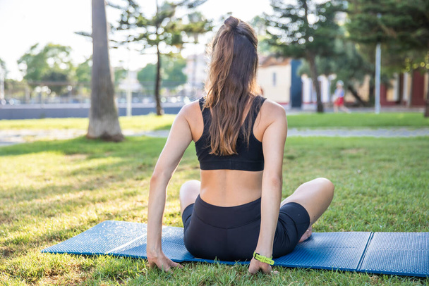 Pretty woman doing yoga in morning park. Healthy lifestyle outdoor conception. Sport. Woman nature portrait doing exercises. Healthy lifestyle. - Photo, image