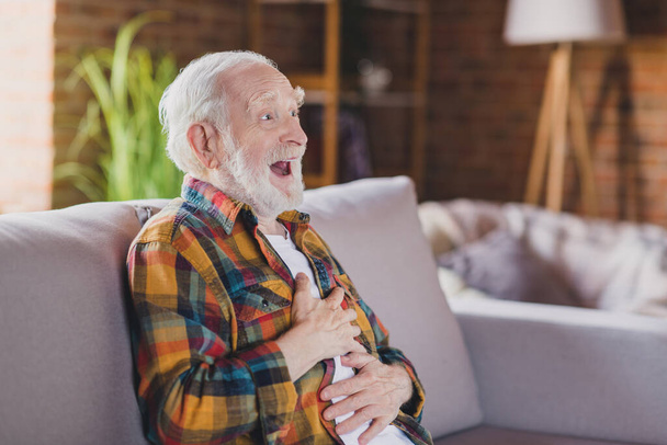 Photo of cheerful grandparent white hair watch comedy show movie laughing dressed casual plaid outfit sit cozy couch indoors home flat room. - Foto, immagini