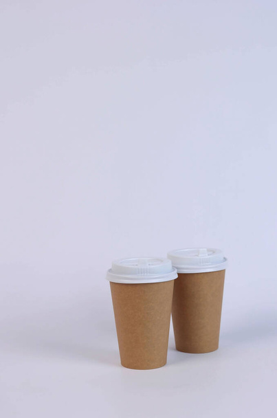 δύο καφέ χάρτινα γυαλιά σε λευκό φόντο. Υψηλής ποιότητας φωτογραφία - Φωτογραφία, εικόνα