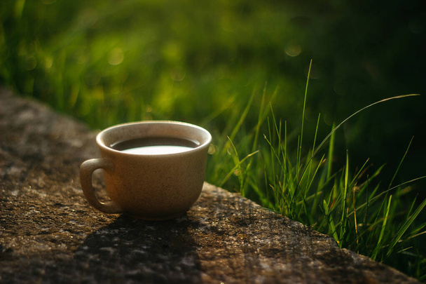 a cup of coffee on the background of the sunset.cup of coffee in the sunset - Фото, изображение