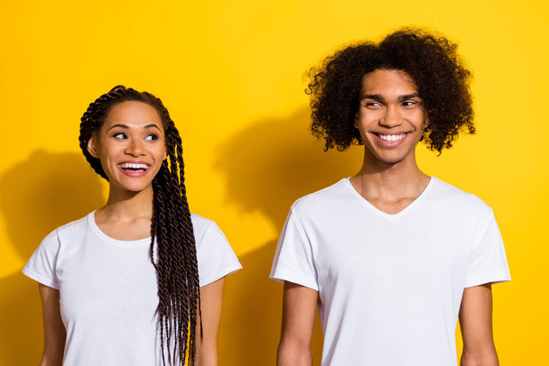 Photo of two cheerful positive people look interested each other toothy smile isolated on yellow color background. - Foto, imagen