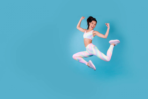Full length photo of excited chinese girl fists fitness sales banner dressed stylish sporty clothes isolated on vivid blue color background. - Foto, Bild