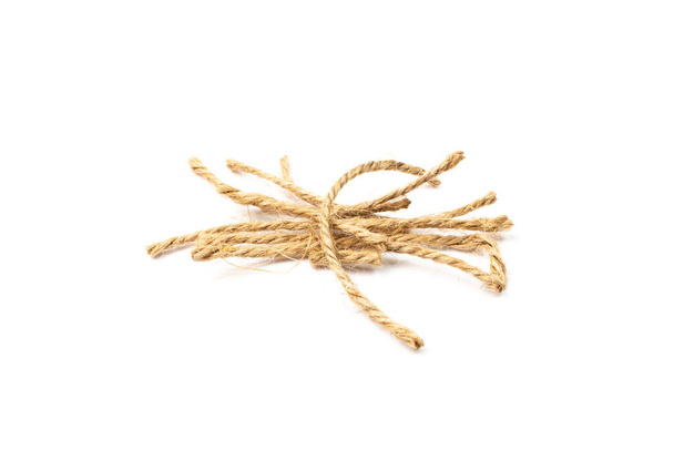 String piece isolated. Jute rope fragment, part of packaging cord knots, eco-friendly natural rope pieces - Photo, Image