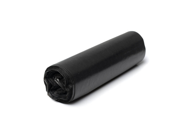 Garbage bag roll isolated. Trash package, new rolled plastic bin bags, black polyethylene waste container on white background - Photo, image