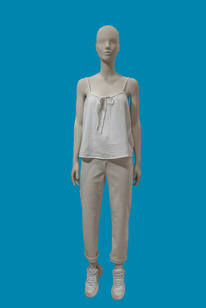 Full length image of a female display mannequin wearing casual clothes isolated on blue background - Foto, afbeelding