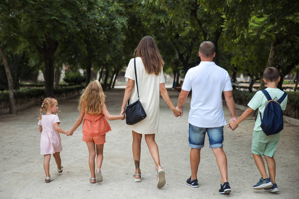 Family spending time together, cheerful parent with kids walking in the park in good weather - Foto, Imagen