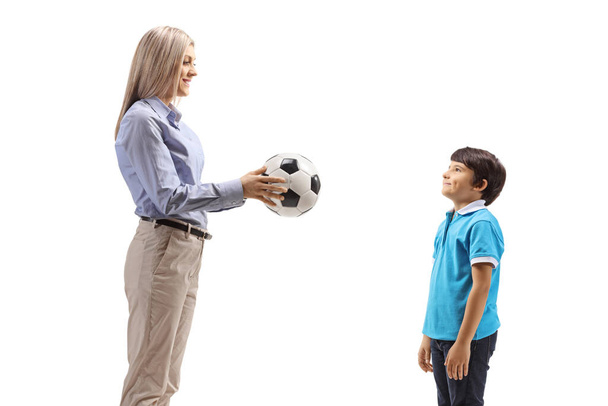 Мати віддає сину футбольний м "яч на білому фоні. - Фото, зображення