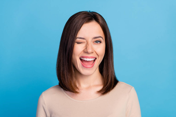 Portrait of overjoyed satisfied lady eye wink beaming smile isolated on blue color background. - Foto, imagen