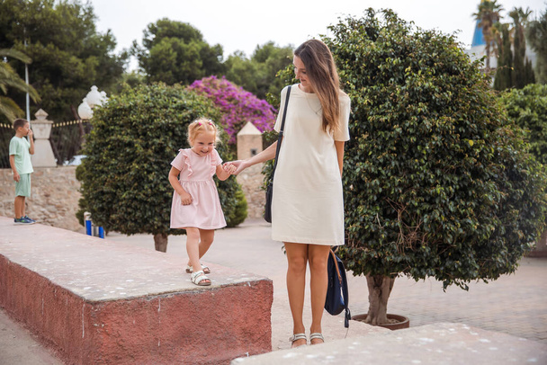 A mother with children walks in a city park, family vacation, the concept of a healthy lifestyle and family leisure - Φωτογραφία, εικόνα