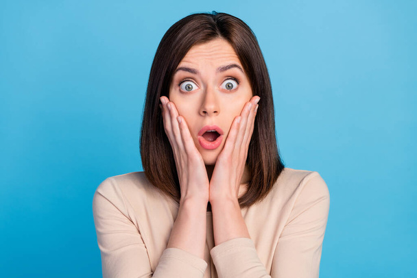 Photo of shocked young pretty lady arms touch cheeks open mouth isolated on blue color background. - 写真・画像