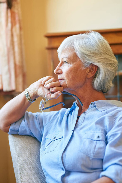 The changes of life come suddenly and swiftly. a senior woman looking thoughtful at home - Foto, Bild
