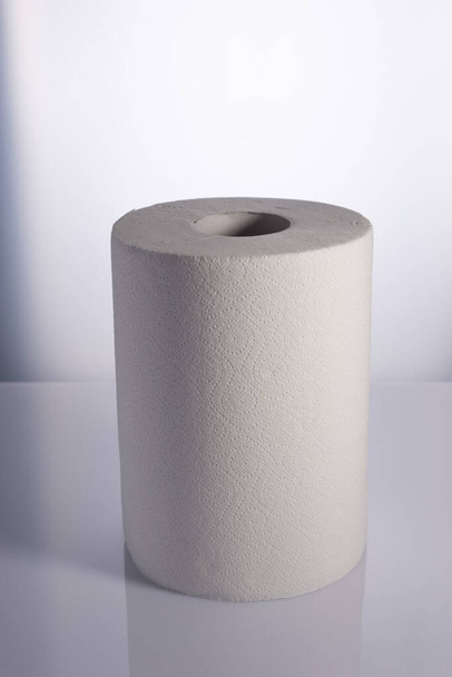 Roll of white disposable nonwoven fabric napkins isolated on white. - Photo, Image