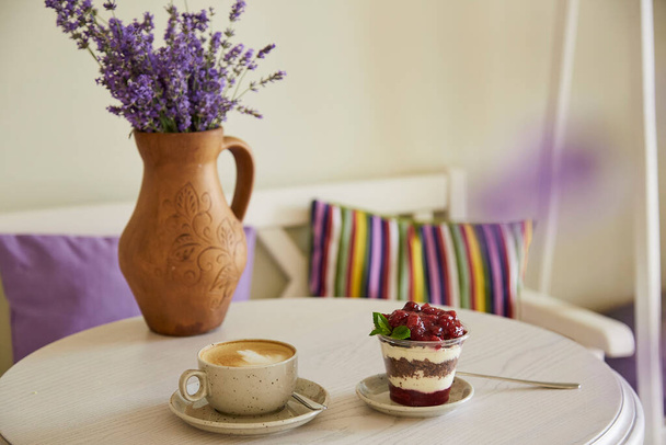 Natural vegan, healthy layered, sugar free dessert with fresh fruits and berries. Cup of coffee, coffee time in the cafe. Lavender decorations - Valokuva, kuva