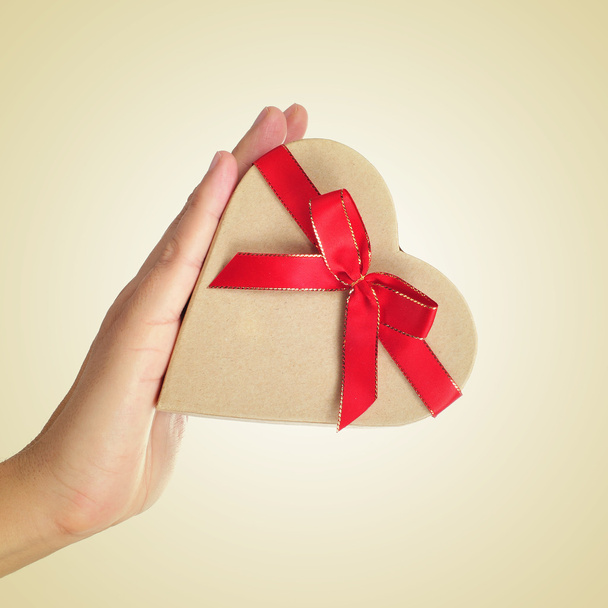 boîte cadeau en forme de coeur dans la main d'un homme
 - Photo, image