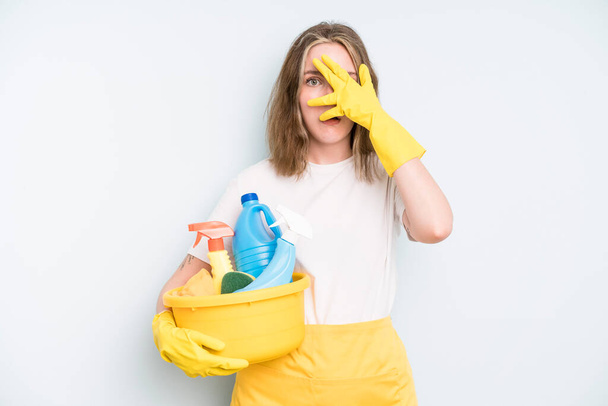 caucasian pretty woman looking shocked, scared or terrified, covering face with hand. housekeeper cleaning concept - Photo, Image