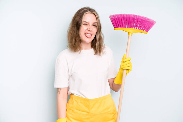 caucasian pretty woman with cheerful and rebellious attitude, joking and sticking tongue out. housekeeper cleaning concept - 写真・画像