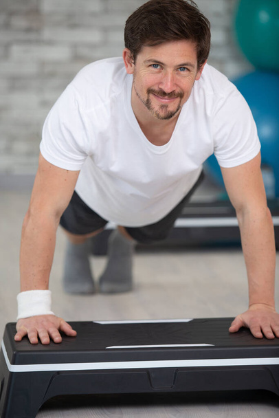 handsome man doing plank in fitness gym - Fotó, kép