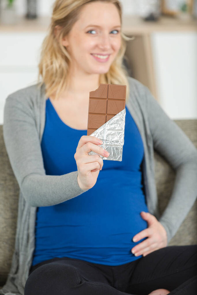 beautiful young pregnant woman eating chocolate - Fotoğraf, Görsel