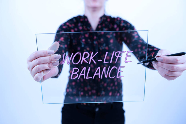 Writing displaying text Work Life Balance, Business showcase Division of time between working or family and leisure Lady standing front backdrop holding presentation achieving project goals. - Photo, Image