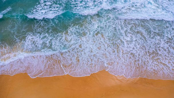Beautiful sea waves and white sand beach in the tropical island. Soft waves of blue ocean on sandy beach background from top view from drones. Concept of relaxation and travel on vacation. - Photo, image