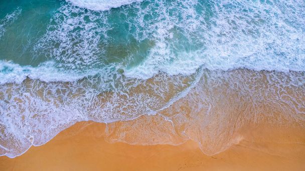Beautiful sea waves and white sand beach in the tropical island. Soft waves of blue ocean on sandy beach background from top view from drones. Concept of relaxation and travel on vacation. - Foto, Imagem