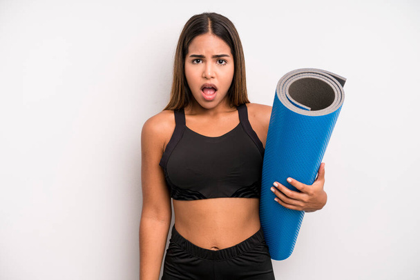 hispanic pretty woman looking very shocked or surprised. fitness and yoga concept - Фото, изображение