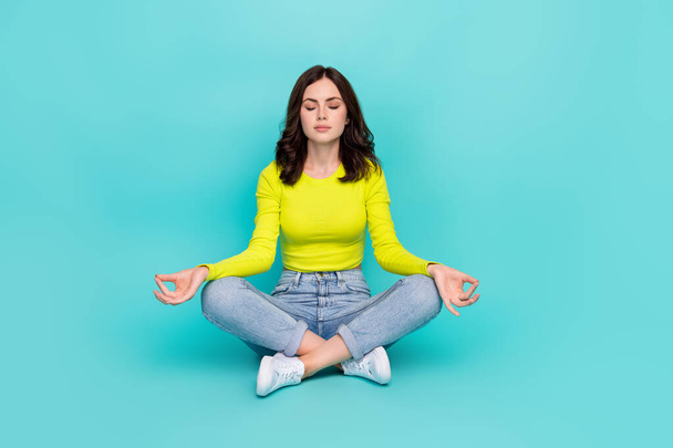 Full size photo of charming girl sit floor crossed legs closed eyes meditate isolated on teal color background. - Фото, изображение